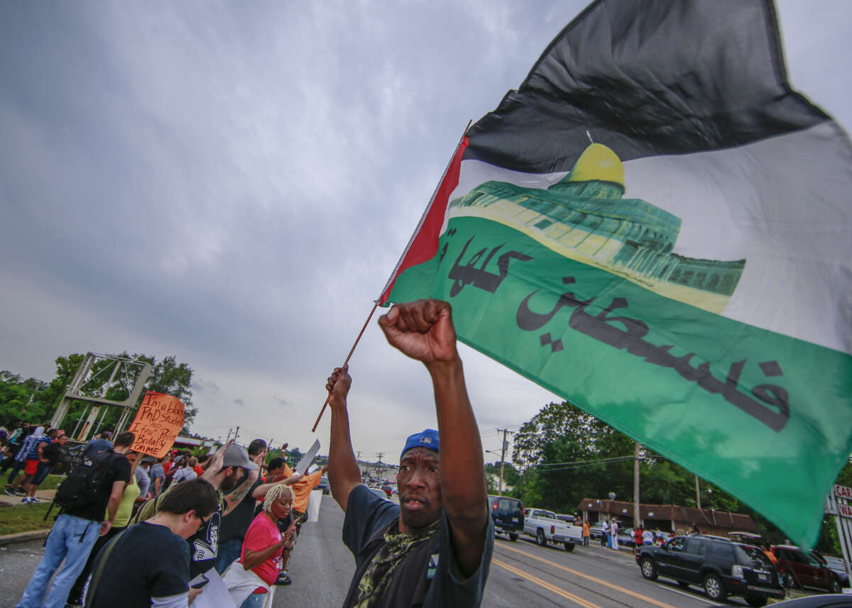 A protester waves a Palestinian flag at a protest against police brutality in Ferguson, Missouri