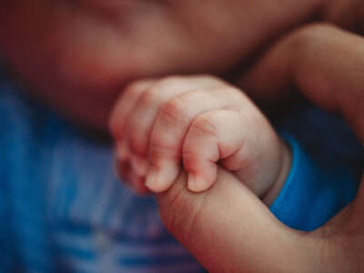 Close-up of parent hand holding baby's hand