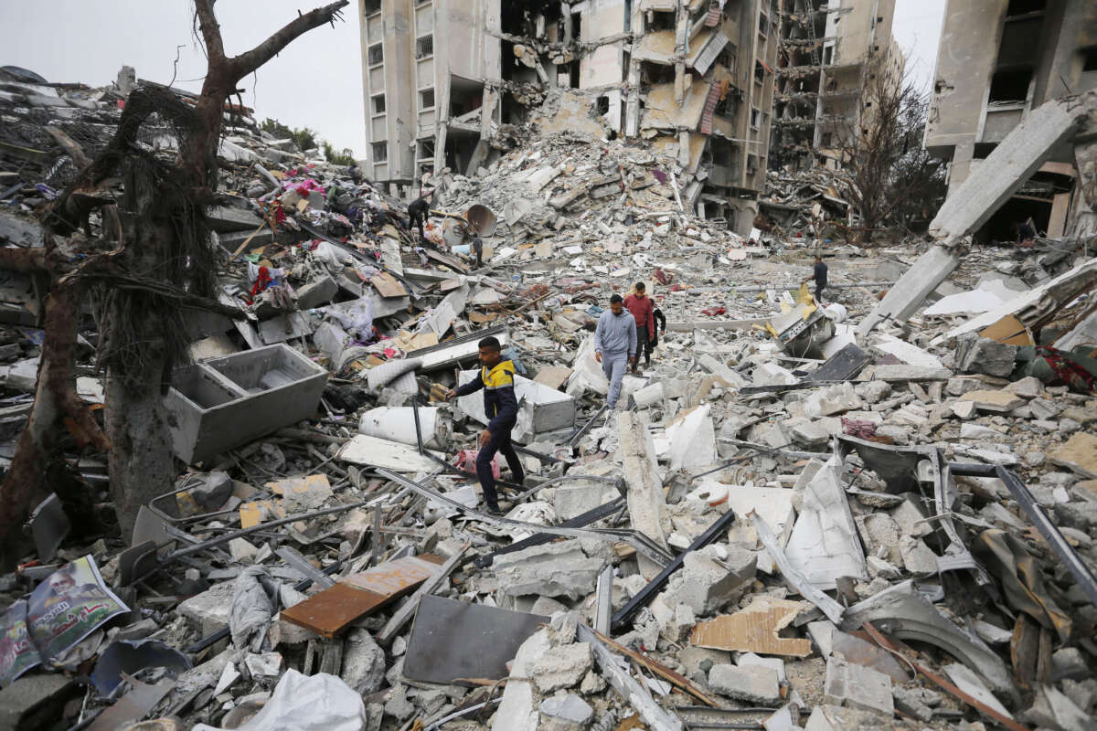Palestinians walk amid the destroyed Ayin Calut apartment at the Nasirat Refugee Camp after Israeli forces withdrew from the area in Gaza City, Gaza, on January 17, 2024.