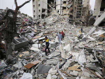 Palestinians walk amid the destroyed Ayin Calut apartment at the Nasirat Refugee Camp after Israeli forces withdrew from the area in Gaza City, Gaza, on January 17, 2024.