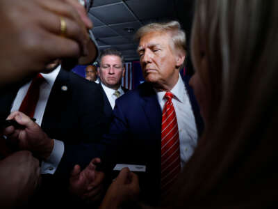 Former President Donald Trump signs autographs and shakes hands with supporters at the conclusion of a campaign rally in the basement ballroom of The Margate Resort on January 22, 2024, in Laconia, New Hampshire.