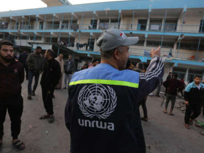 Palestinians gather their belongings and leave the area after Israeli airstrike hit Al-Maghazi School affiliated with UNRWA at Al-Maghazi refugee camp in Gaza Strip on December 27, 2023.