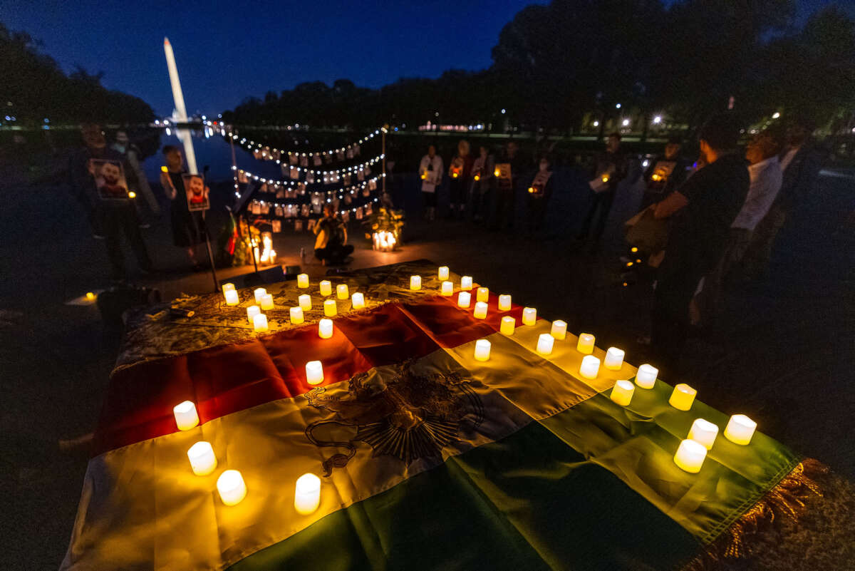 The Washington Monument is seen through a display of photos of protesters killed by Iran's regime during a candlelight vigil at the Lincoln Memorial honoring Mahsa Zhina Amini and the demonstrators. The event marks the first anniversary of Amini's murder and the beginning of Woman, Life, Freedom movement for a free Iran.