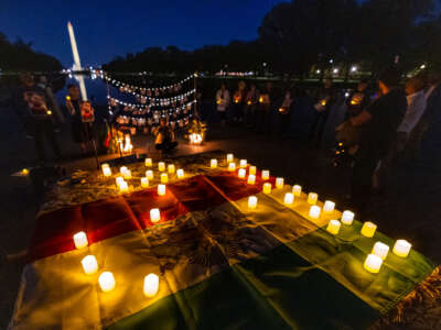 The Washington Monument is seen through a display of photos of protesters killed by Iran's regime during a candlelight vigil at the Lincoln Memorial honoring Mahsa Zhina Amini and the demonstrators. The event marks the first anniversary of Amini's murder and the beginning of Woman, Life, Freedom movement for a free Iran.