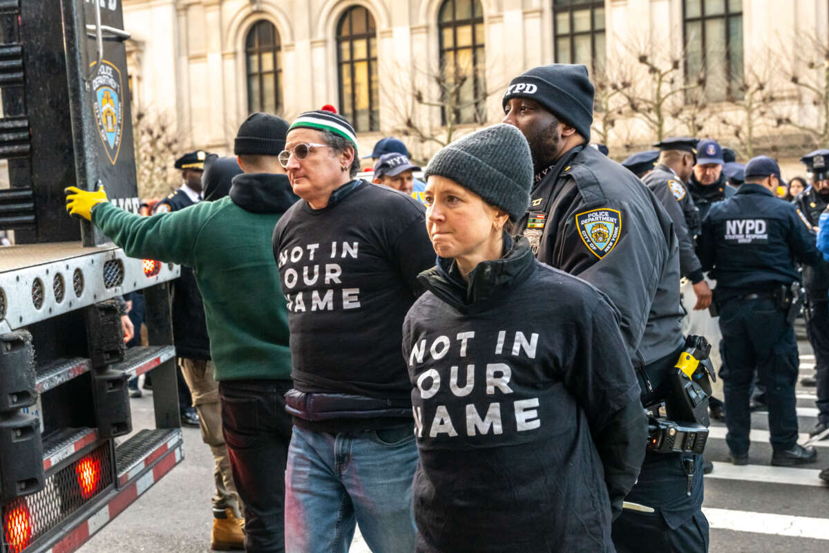 NYPD lead away two handcuffed demonstrators as hundreds of Jewish demonstrators gathered in New York City to protest against the United States' continued funding of Israel's war on Gaza and to call for a permanent ceasefire.