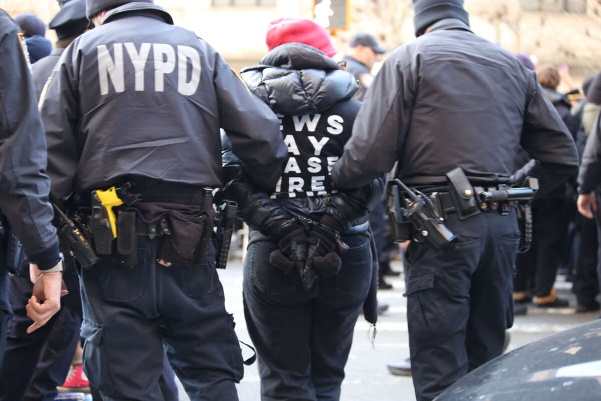 NYPD officers lead away a handcuffed protester as hundreds of Jewish demonstrators gathered in New York City to protest against the United States' continued funding of Israel's war on Gaza and to call for a permanent ceasefire.