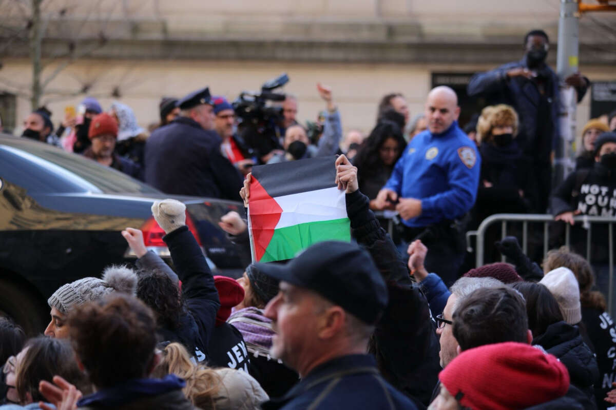 A demonstrator holds a Palestinian flag as hundreds of Jewish demonstrators gathered in New York City to protest against the United States' continued funding of Israel's war on Gaza and to call for a permanent ceasefire.