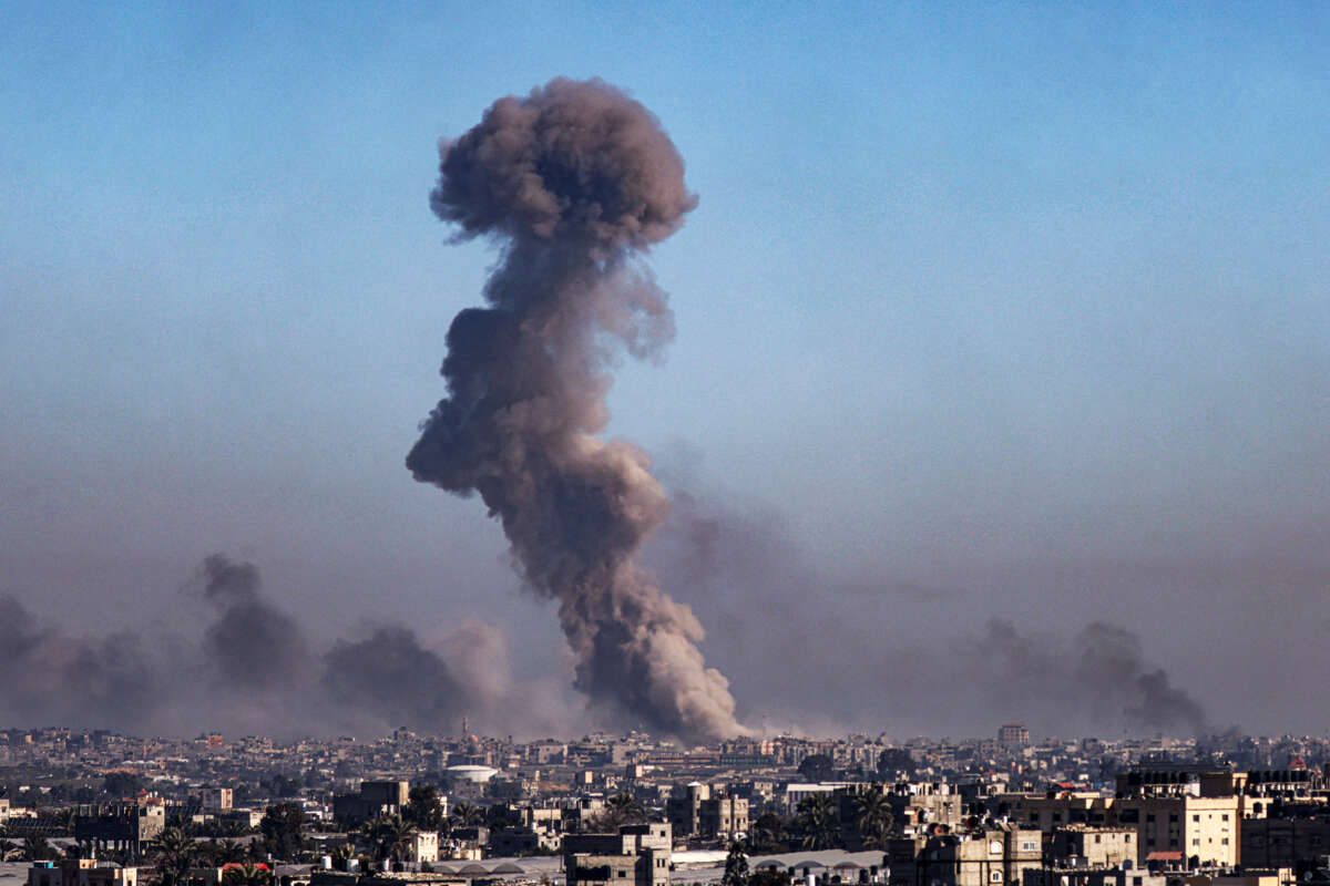 A large plume of smoke is seen on the horizon from Israeli airstrikes against Palestinian civialians