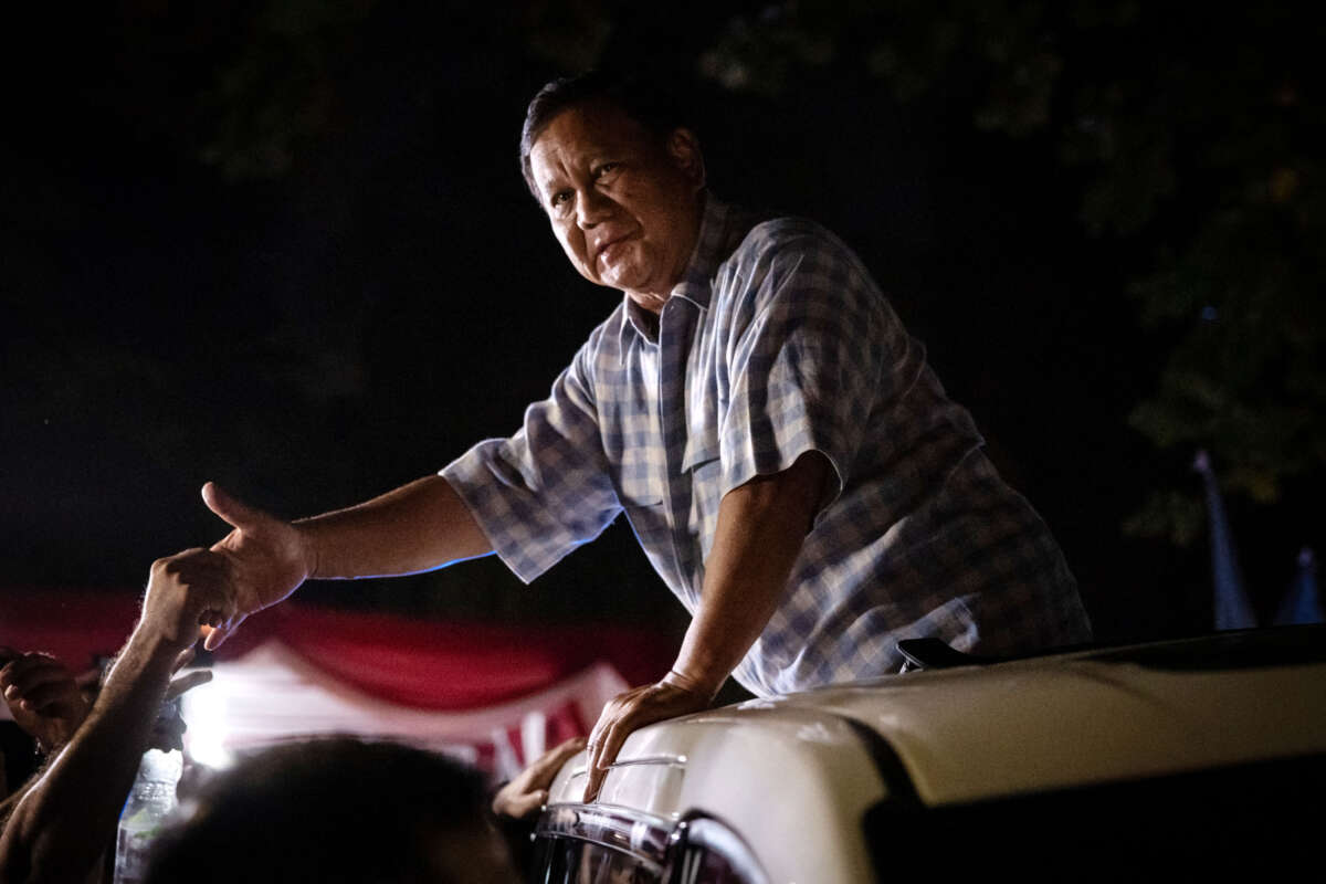 Indonesian Defense Minister Prabowo Subianto reacts to supporters from a car as he leaves his residence to attend a gathering with supporters after polls closed in the country's presidential and legislative elections in Jakarta on February 14, 2024.