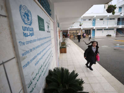 A Palestinian student walks out of a UNRWA school with a lunchbox in her hand at al-Am'ari Refugee Camp after funding cuts to UNRWA in Ramallah, West Bank, on February 3, 2024.