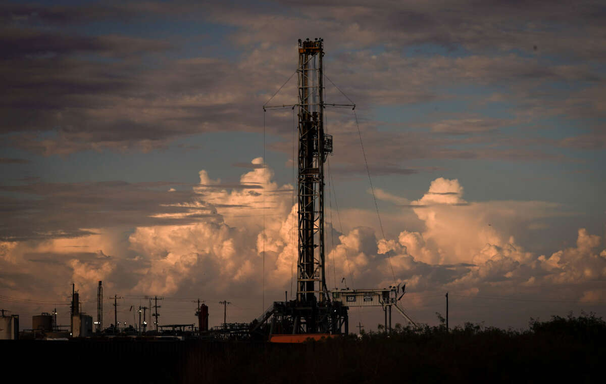 A drilling rig operates as the sun sets on July 6, 2022, in Pecos, Texas.