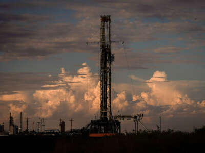 A drilling rig operates as the sun sets on July 6, 2022, in Pecos, Texas.