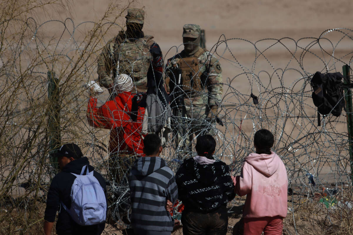 National Guards, migrants and wire-spikes on the border are seen in Ciudad Juarez, Mexico, on January 29, 2024.