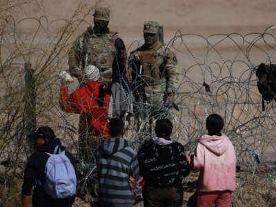 National Guards, migrants and wire-spikes on the border are seen in Ciudad Juarez, Mexico, on January 29, 2024.