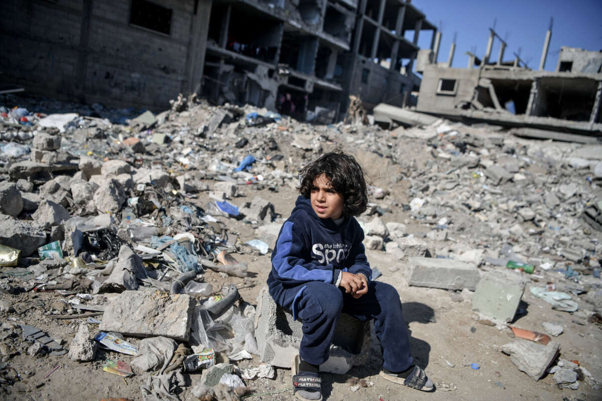 A Palestinian child sits among the rubble of buildings destroyed by Israeli attacks in Rafah, Gaza, on February 21, 2024.