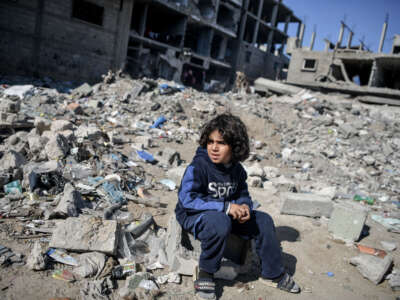 A Palestinian child sits among the rubble of buildings destroyed by Israeli attacks in Rafah, Gaza, on February 21, 2024.