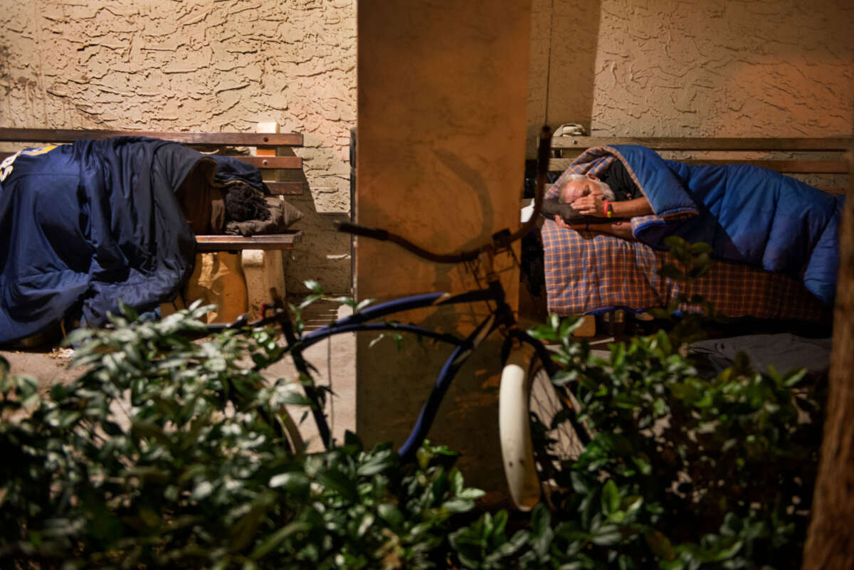 Unhoused people bed down for the night outdoors in the alcoves of the Sarasota County Jail building in Sarasota, Florida, on April 8, 2016.