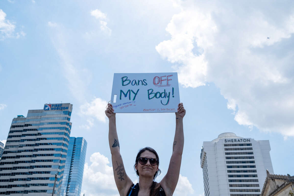 A protester holds a sign reading "BANS OFF MY BODY" during an outdoor protest