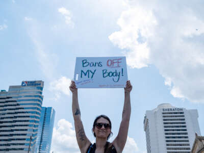 A protester holds a sign reading "BANS OFF MY BODY" during an outdoor protest