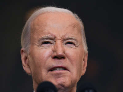 Joe biden makes a face while speaking at a podium