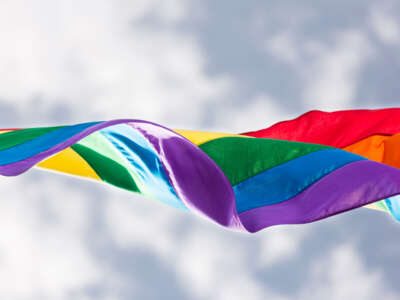Pride flag blowing in wind over sky