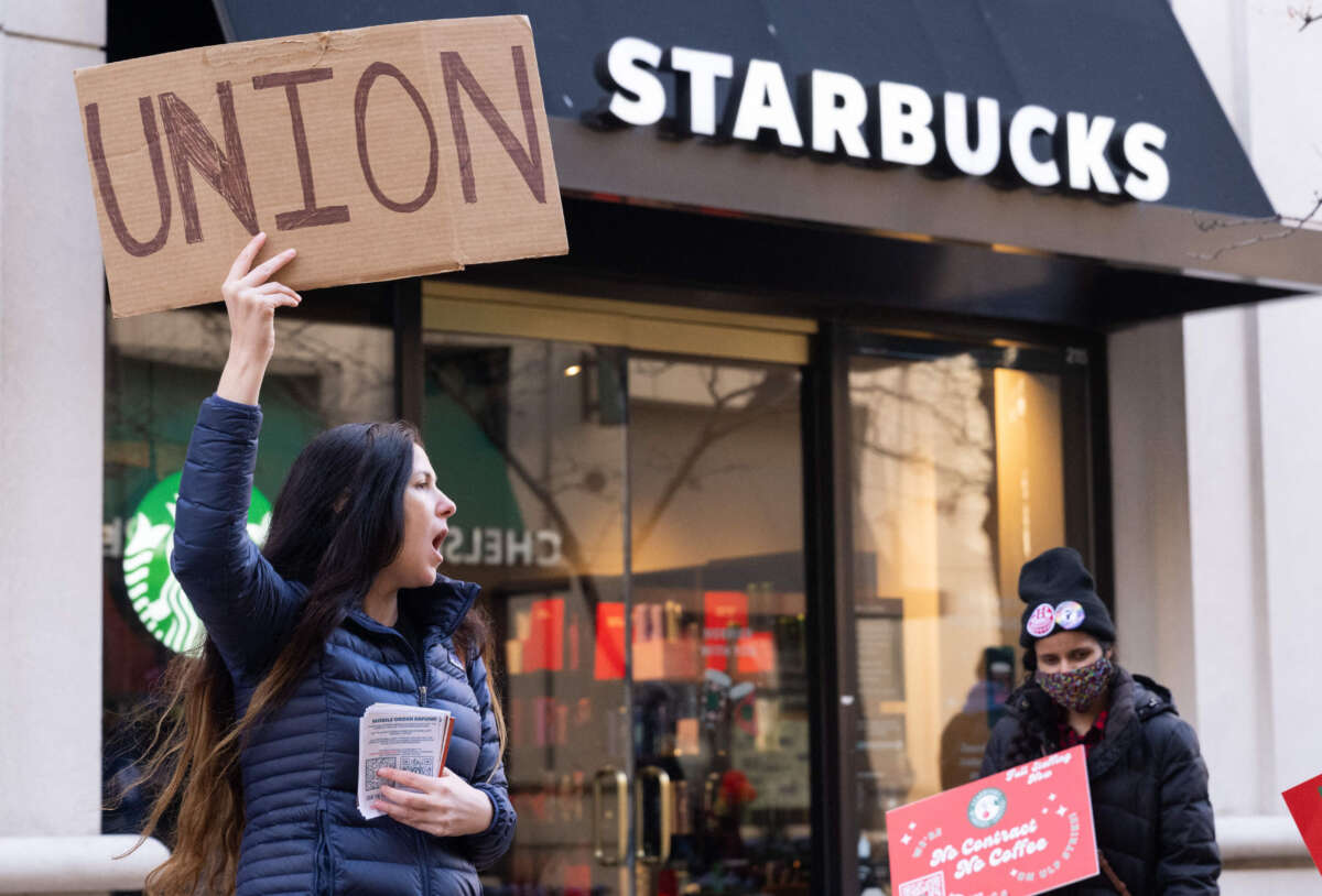 Starbucks workers, former employees, and supporters hold signs in support of a strike, outside of a Starbucks store in Arlington, Virginia, on November 16, 2023.