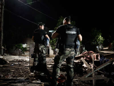 French gendarmes stand guard at night in front of demolished buildings in the shantytown of "Talus 2" district in Koungou, as part of Operation Wuambushu on the French Indian Ocean island of Mayotte, on May 25, 2023. Authorities in Mayotte are carrying out Operation Wuambushu ("Take Back" in the local language) to clear slums, demolishing the makeshift settlements and sending migrants back to neighboring Comoros.