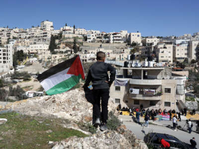 Palestinians gather to perform Friday prayer outside an apartment faces the threat of demolition by Israeli municipal authority in the Wadi Qadum neighborhood of Silwan, in East Jerusalem, on February 17, 2023.