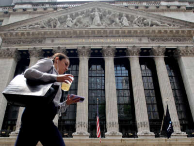 Woman walks past the New York stock exchange