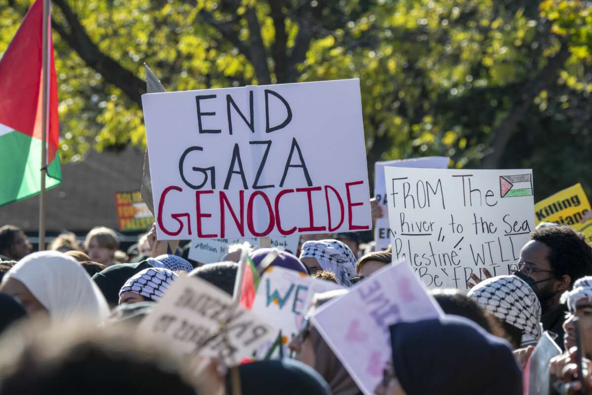 Protesters hold sign saying "end gaza genocide"