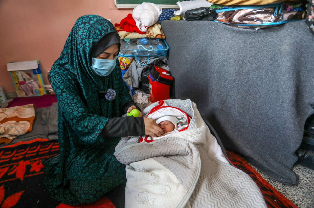 Palestinian woman feeds her baby in Gaza