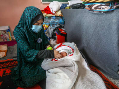 Palestinian woman feeds her baby in Gaza