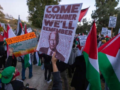 A protester holds a sign depicting President Joe Biden reading "Come November We'll Remember" on December 8, 2023, in Los Angeles, California.