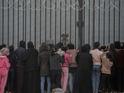 Palestinians talk to an Egyptian soldier at the Rafah border fence in Rafah, Gaza, on January 11, 2024.