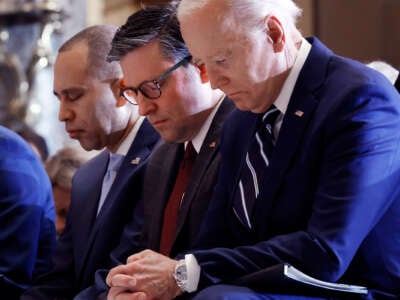 Joe Biden bows his head and prays