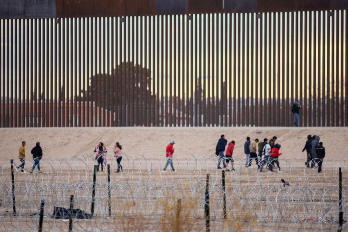 People walk along the border wall at the U.S./Mexico border