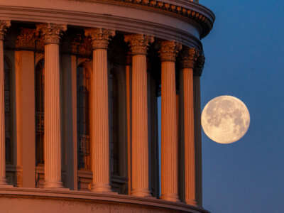The moon sets behind the U.S. Capitol Dome on February 25, 2024, in Washington, D.C.