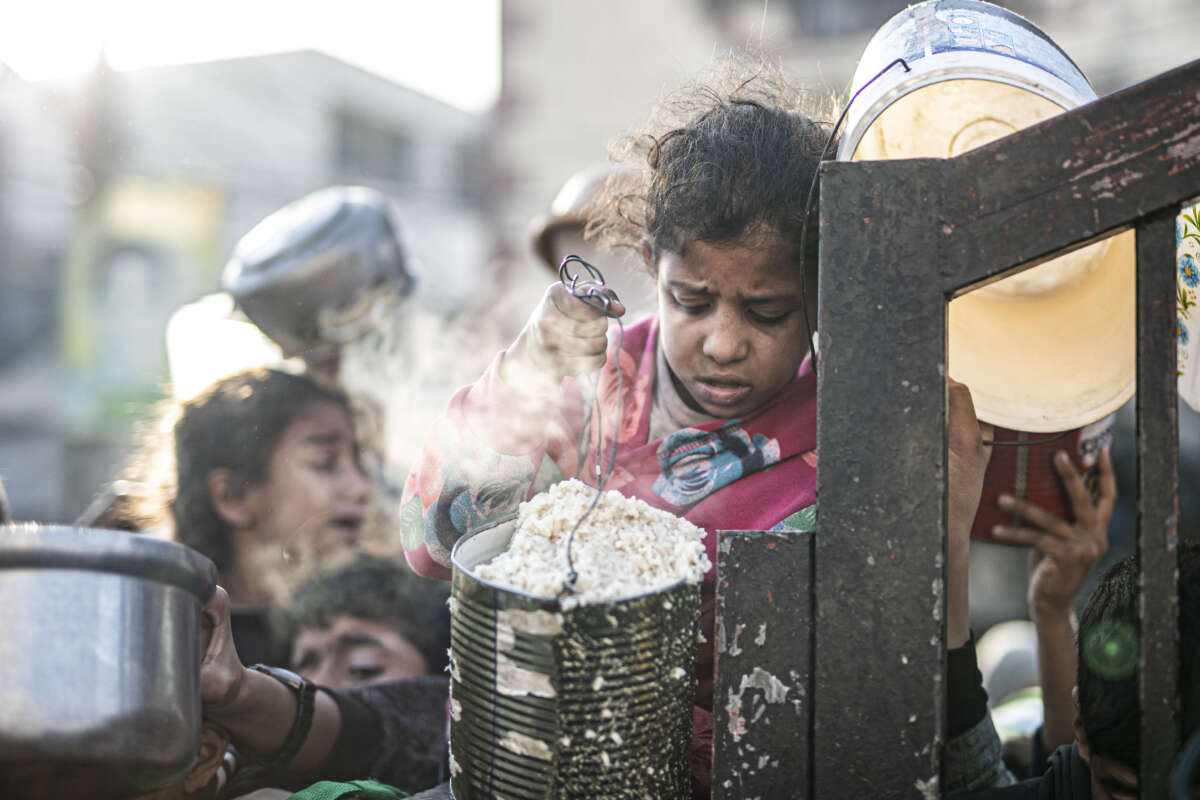 Palestinians in Rafah, Gaza, line up to receive food distributed by aid organizations on March 15, 2024.