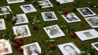 Pictures of people who were killed or went missing during the 1964-1985 dictatorship are layed out on the ground during a demonstration on the 58th anniversary of the military coup at Ibirapuera Park, in São Paulo, Brazil, on March 31, 2022.
