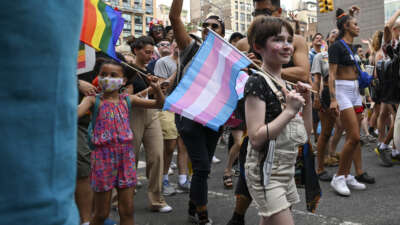 A child carrying a trans pride flag at a march in New York City
