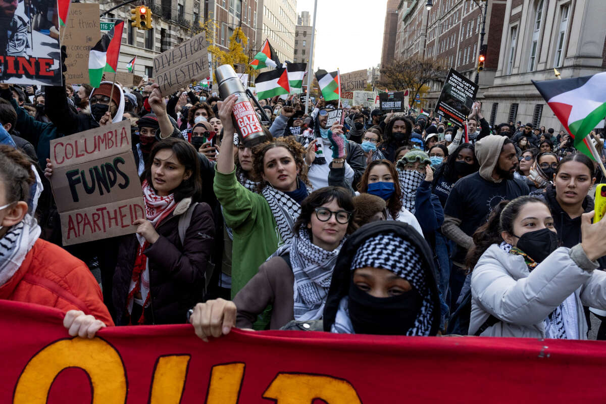 Pro-Palestine student demonstrators wave flags and wear keffiyehs at a march in New York City