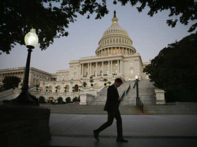 A silhouette walks past U.S. Capitol building at dusk