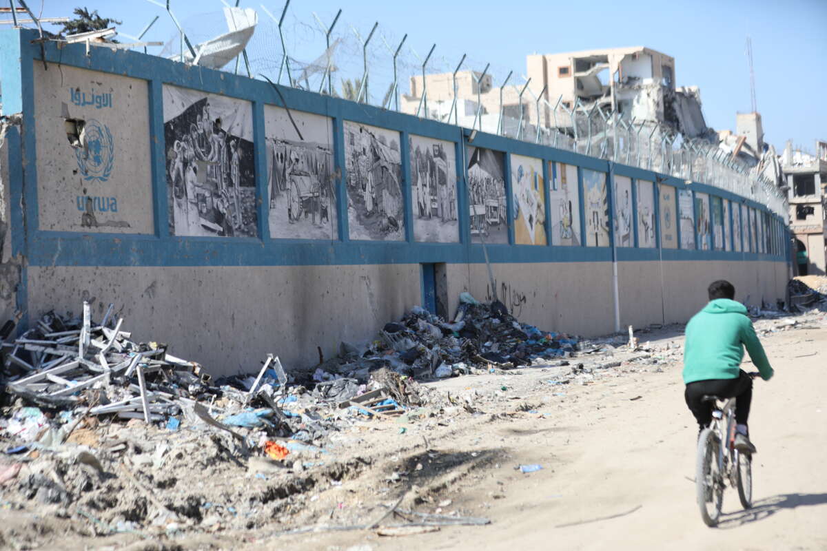 A man bikes by the UNRWA headquarters, which has been destroyed by Israeli attacks, in Gaza City, Gaza, on February 21, 2024.