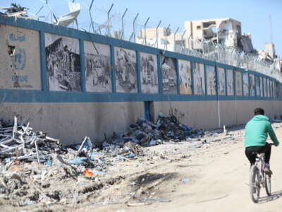 A man bikes by the UNRWA headquarters, which has been destroyed by Israeli attacks, in Gaza City, Gaza, on February 21, 2024.
