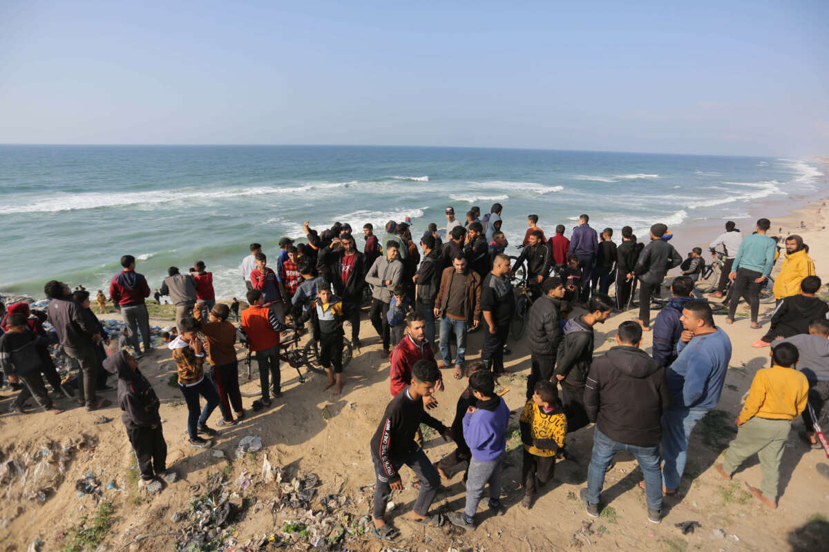 Palestinians wait for a humanitarian aid airdrop at the beach in Deir al Balah, Gaza, on February 27, 2024.