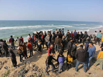 Palestinians wait for a humanitarian aid airdrop at the beach in Deir al Balah, Gaza, on February 27, 2024.