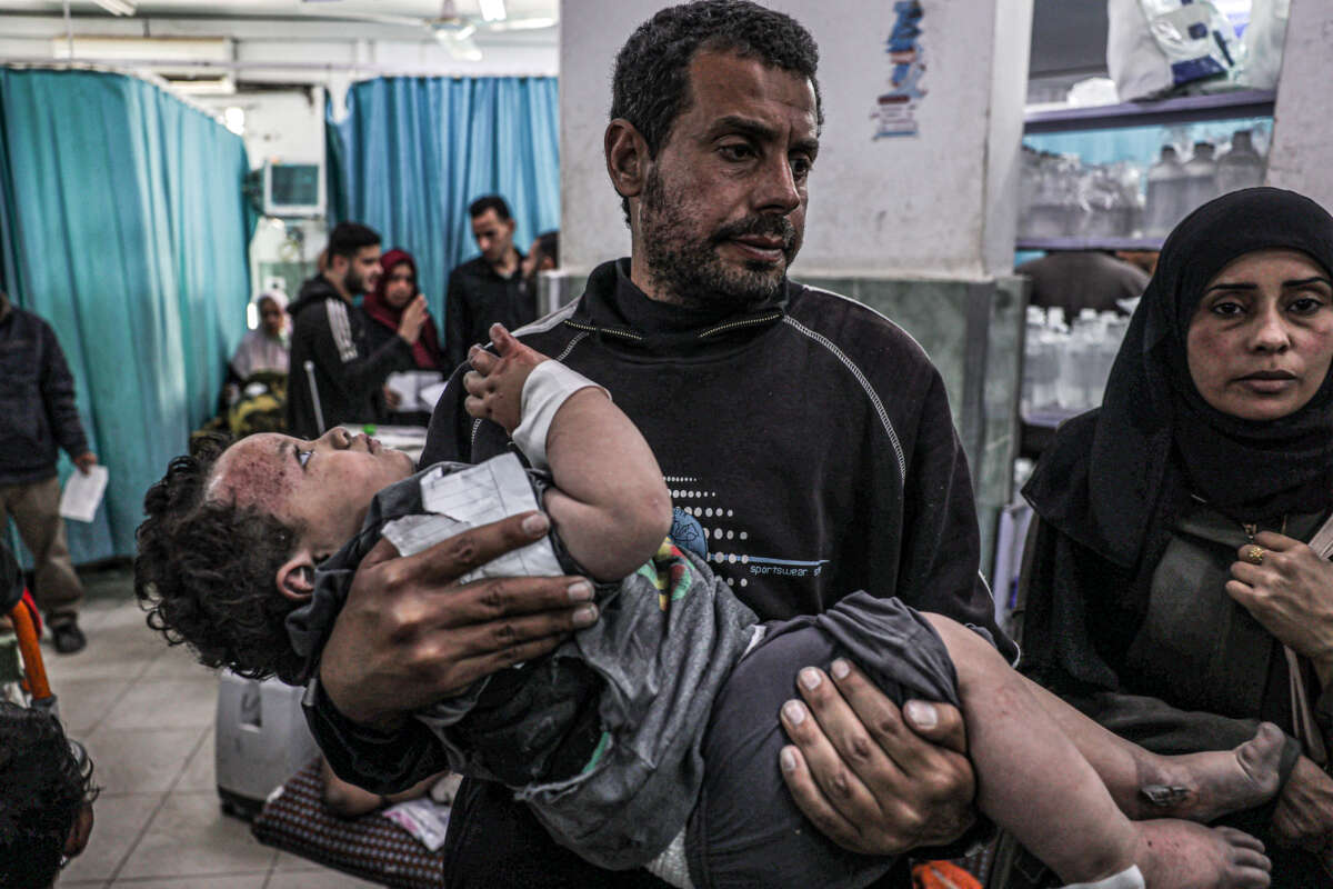 A man carries a child, who was injured in an Israeli air strike, at the trauma ward at Al-Najjar hospital in Rafah in the southern Gaza Strip, on March 20, 2024.