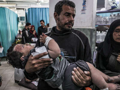 A man carries a child, who was injured in an Israeli air strike, at the trauma ward at Al-Najjar hospital in Rafah in the southern Gaza Strip, on March 20, 2024.