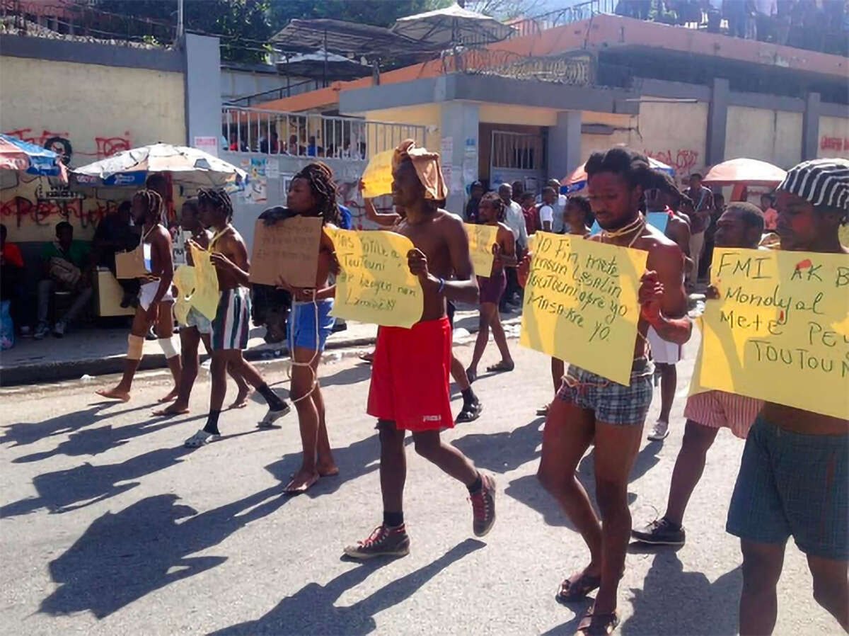 Community leaders, including members of MOLEGHAF leaders, rally and perform teyat popilè (guerrilla theater) on Avenue John Brown in Port-au-Prince, Haiti, after the 2018 Lasalin massacre.]