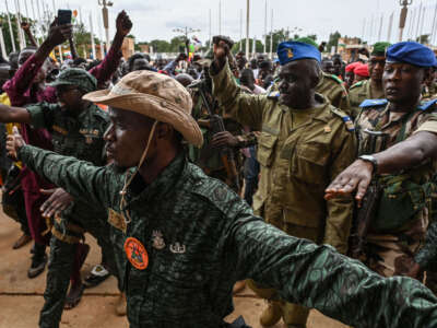 Niger's National Council for the Safeguard of the Homeland (CNSP) Col. Maj. Amadou Abdramane (second right) is greeted by supporters upon his arrival at the Stade Général Seyni Kountché in Niamey on August 6, 2023.